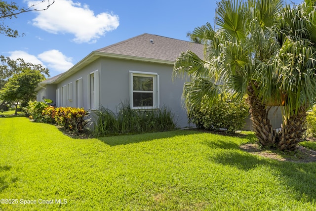 1035 Quail Ct SW, Vero Beach, FL 32968 - view of property exterior featuring roof with shingles, stucco siding, and a yard