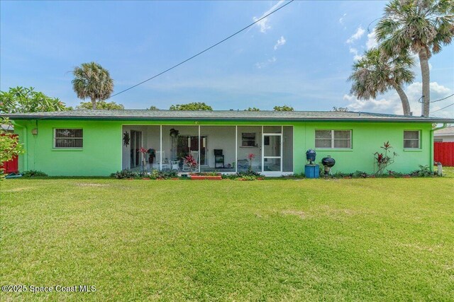 306 Glen Ridge Rd, Cocoa, FL 32926 - back of house with a yard, stucco siding, and a sunroom