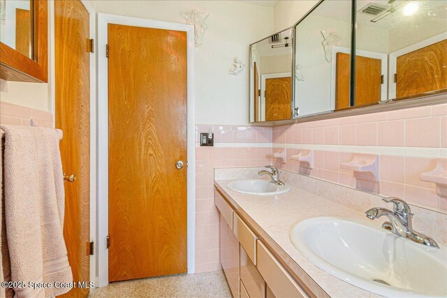 306 Glen Ridge Rd, Cocoa, FL 32926 - full bath featuring speckle patterned floor, double vanity, and tile walls