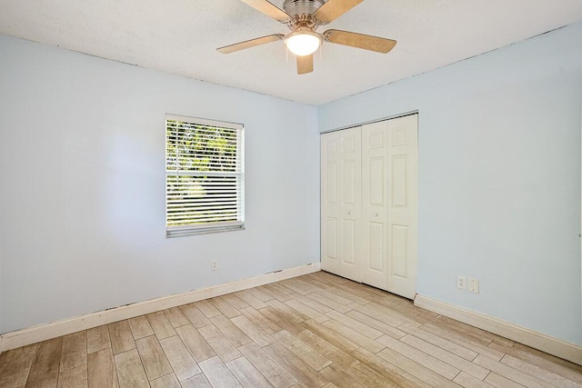 517 Fulton St, Daytona Beach, FL 32114 - unfurnished bedroom featuring light wood-style floors, baseboards, a closet, and a ceiling fan
