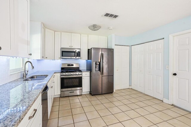 517 Fulton St, Daytona Beach, FL 32114 - kitchen with stainless steel appliances, a sink, white cabinetry, and light stone countertops