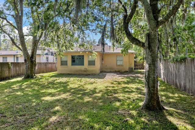 517 Fulton St, Daytona Beach, FL 32114 - rear view of house with stucco siding and central AC unit