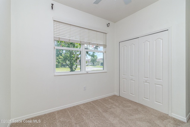 122 Port Royal Cir, Sebastian, FL 32958 - unfurnished bedroom featuring carpet flooring, baseboards, a closet, and a ceiling fan