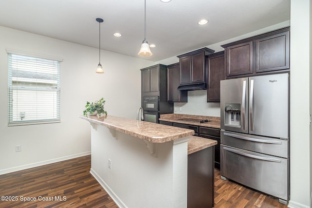 122 Port Royal Cir, Sebastian, FL 32958 - kitchen with black appliances, dark brown cabinets, light countertops, a kitchen bar, and recessed lighting