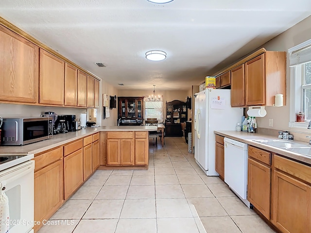 4432 Freedom Rd, Kissimmee, FL 34746 - kitchen with white appliances, a chandelier, a sink, a peninsula, and light countertops