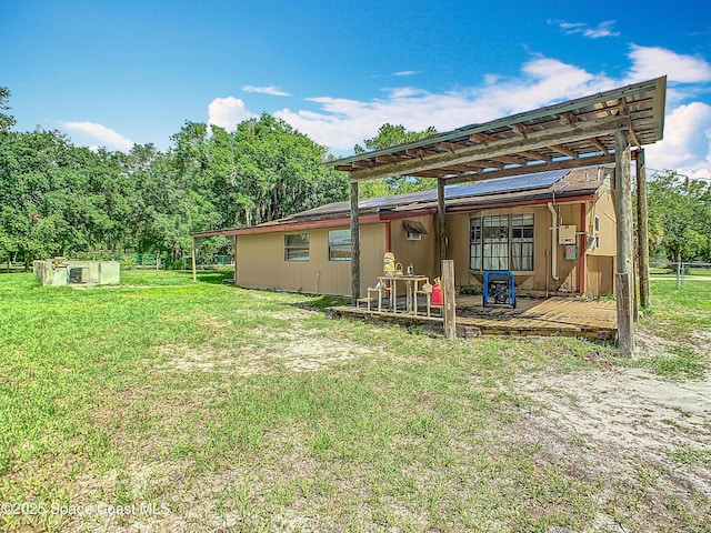 4432 Freedom Rd, Kissimmee, FL 34746 - rear view of property with a lawn, a wooden deck, and solar panels