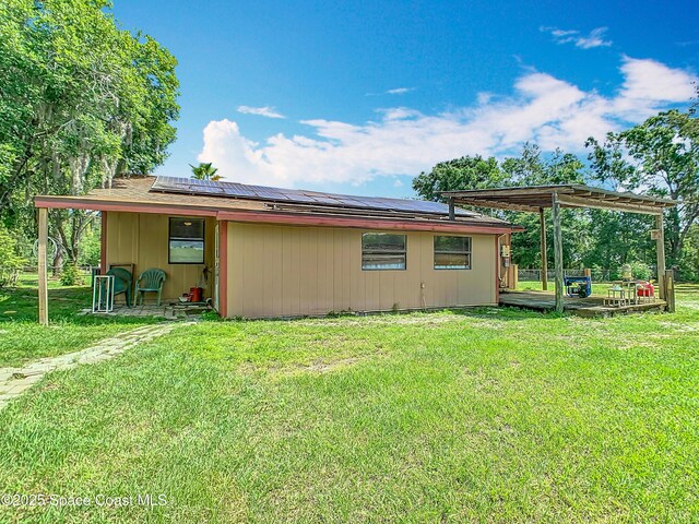 4432 Freedom Rd, Kissimmee, FL 34746 - rear view of house featuring solar panels and a yard