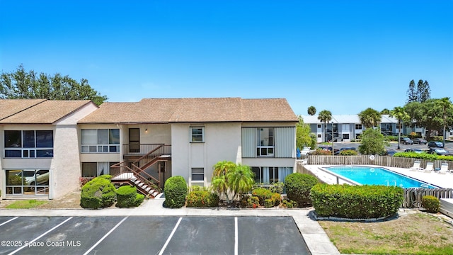 2500 Eagle Dr Unit 4-H, Melbourne, FL 32935 - view of property with uncovered parking, fence, a community pool, and a residential view