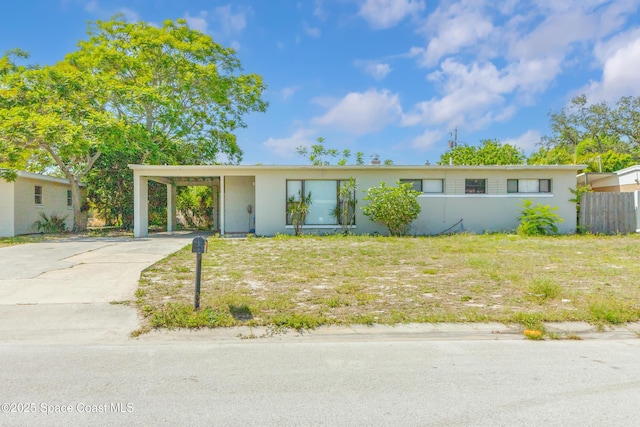 1049 Azalea Ln, Cocoa, FL 32922 - ranch-style house with stucco siding, driveway, and a carport
