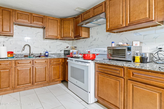 1049 Azalea Ln, Cocoa, FL 32922 - kitchen with electric stove, under cabinet range hood, brown cabinets, and light marble finish flooring