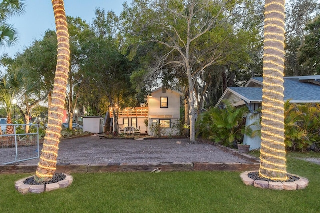 rear view of property featuring a lawn and driveway