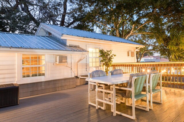 deck featuring outdoor dining area and an AC wall unit