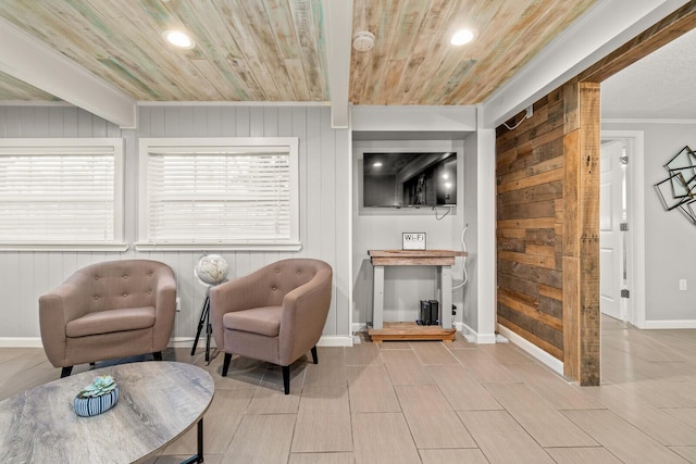 living room featuring ornamental molding, wooden ceiling, baseboards, wooden walls, and wood finish floors