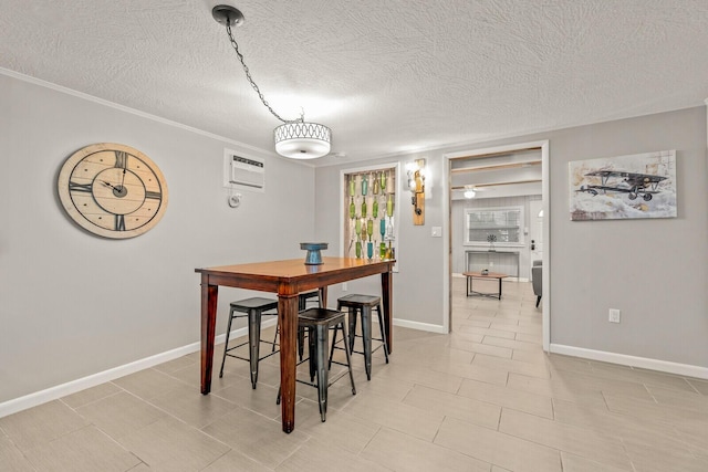 dining space featuring a textured ceiling, baseboards, an AC wall unit, light tile patterned floors, and crown molding