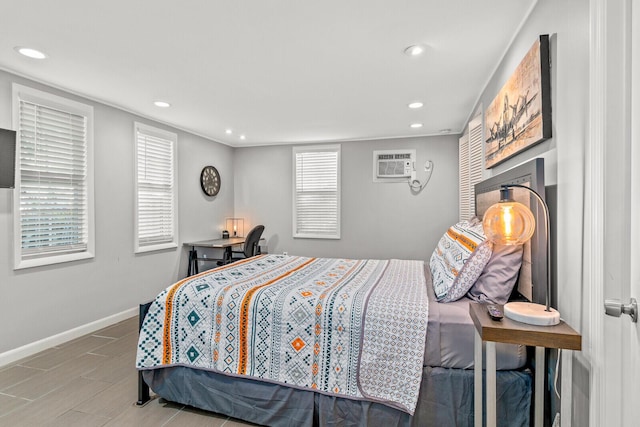 bedroom featuring an AC wall unit, recessed lighting, and baseboards