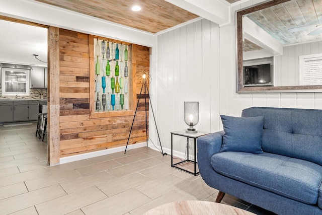 sitting room featuring wood ceiling and wooden walls