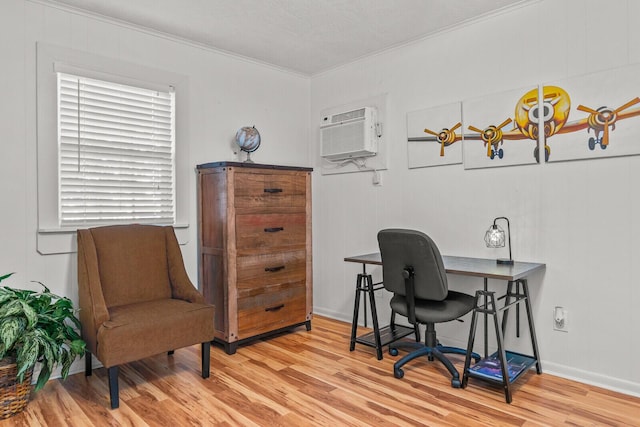 office with ornamental molding, wood finished floors, a wall unit AC, and baseboards
