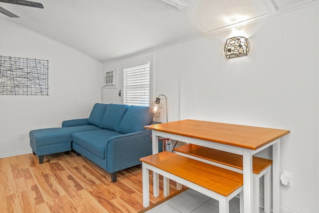 living room with lofted ceiling, light wood-style flooring, and a ceiling fan