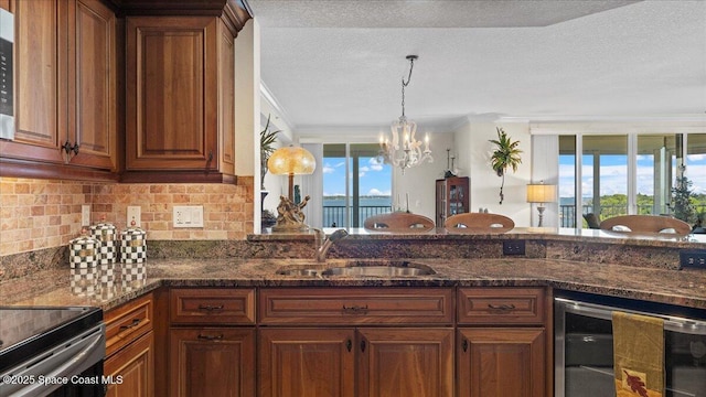 480 Sail Ln Unit 607, Merritt Island, FL 32953 - kitchen with beverage cooler, a sink, a chandelier, tasteful backsplash, and ornamental molding