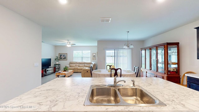 1491 Higbee St SE, Palm Bay, FL 32909 - kitchen with a sink, light countertops, a chandelier, ceiling fan, and decorative light fixtures
