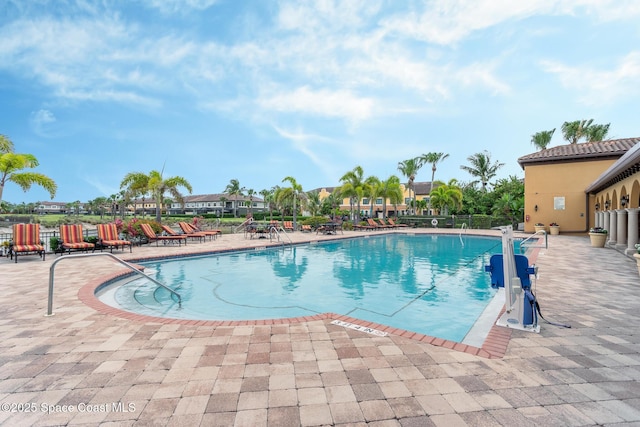 community pool featuring a patio and fence
