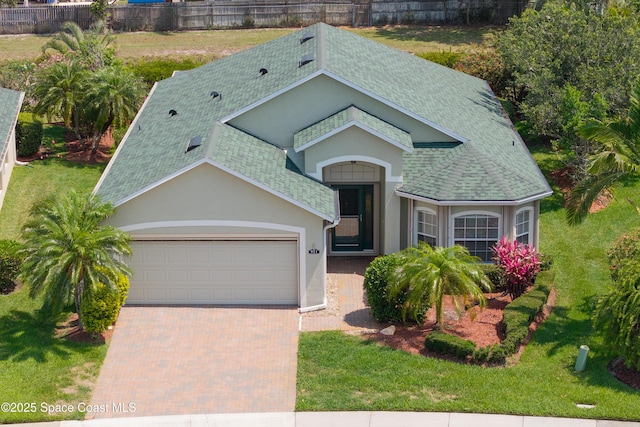 911 Indian Oaks Dr, Melbourne, FL 32901 - view of front of property featuring a shingled roof, an attached garage, stucco siding, and decorative driveway
