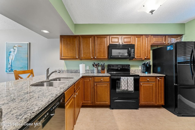 300 Columbia Dr Unit 108-2, Cape Canaveral, FL 32920 - kitchen featuring black appliances, a sink, brown cabinets, light stone countertops, and a textured ceiling