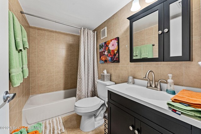 300 Columbia Dr Unit 108-2, Cape Canaveral, FL 32920 - bathroom with tile walls, toilet, shower / tub combo, vanity, and tile patterned flooring