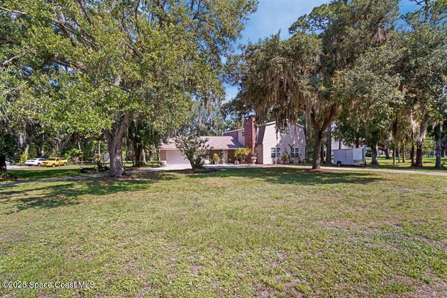 965 Bluegrass Ln, Rockledge, FL 32955 - view of green lawn with an attached garage
