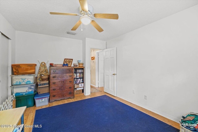965 Bluegrass Ln, Rockledge, FL 32955 - bedroom with wood finished floors, baseboards, a textured ceiling, and ceiling fan