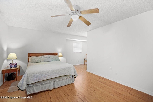 965 Bluegrass Ln, Rockledge, FL 32955 - bedroom featuring a textured ceiling, light wood finished floors, baseboards, and ceiling fan