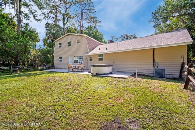 965 Bluegrass Ln, Rockledge, FL 32955 - back of house with a hot tub, a patio, a shingled roof, a gambrel roof, and central AC unit