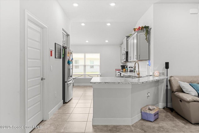 1041 Tupelo Cir, Cocoa, FL 32926 - kitchen featuring stainless steel appliances, a peninsula, a sink, recessed lighting, and light stone counters
