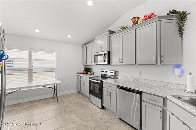 1041 Tupelo Cir, Cocoa, FL 32926 - kitchen featuring appliances with stainless steel finishes, gray cabinets, lofted ceiling, recessed lighting, and light tile patterned floors