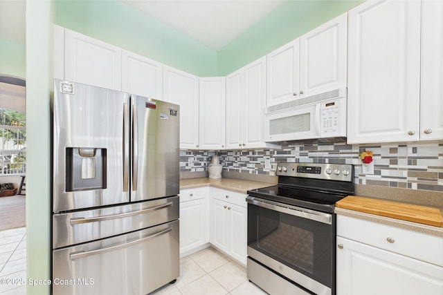 1737 Windbrook Dr SE, Palm Bay, FL 32909 - kitchen featuring appliances with stainless steel finishes, light tile patterned floors, light countertops, backsplash, and white cabinets