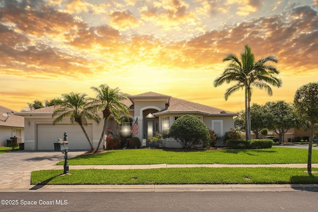 1737 Windbrook Dr SE, Palm Bay, FL 32909 - mediterranean / spanish home with stucco siding, driveway, an attached garage, and a lawn