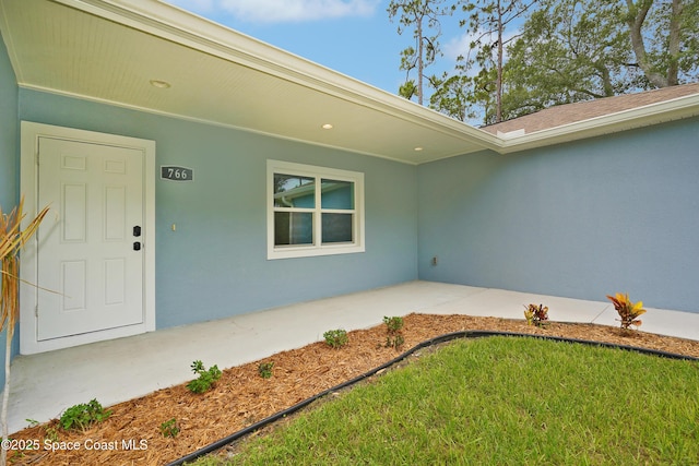766 Tooley Rd SW, Palm Bay, FL 32908 - view of exterior entry with stucco siding and a patio area