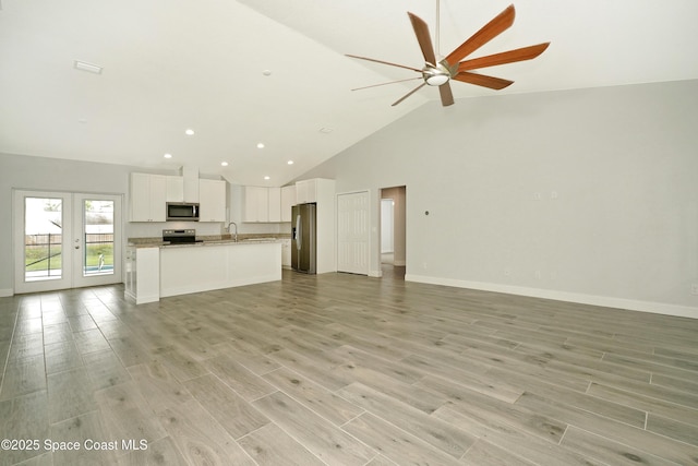766 Tooley Rd SW, Palm Bay, FL 32908 - unfurnished living room with a ceiling fan, high vaulted ceiling, a sink, baseboards, and light wood-type flooring