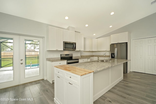 766 Tooley Rd SW, Palm Bay, FL 32908 - kitchen featuring appliances with stainless steel finishes, a sink, a center island with sink, wood finished floors, and white cabinets