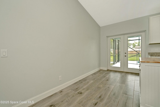 766 Tooley Rd SW, Palm Bay, FL 32908 - empty room with light wood-style flooring, french doors, lofted ceiling, and baseboards