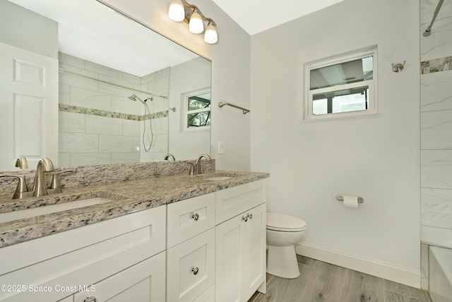 766 Tooley Rd SW, Palm Bay, FL 32908 - bathroom with double vanity, toilet, baseboards, wood finished floors, and tiled shower / bath combo