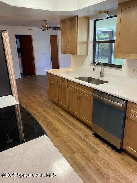 240 Perth Ave, Merritt Island, FL 32953 - kitchen with stainless steel dishwasher, a sink, light wood finished floors, light countertops, and cooktop