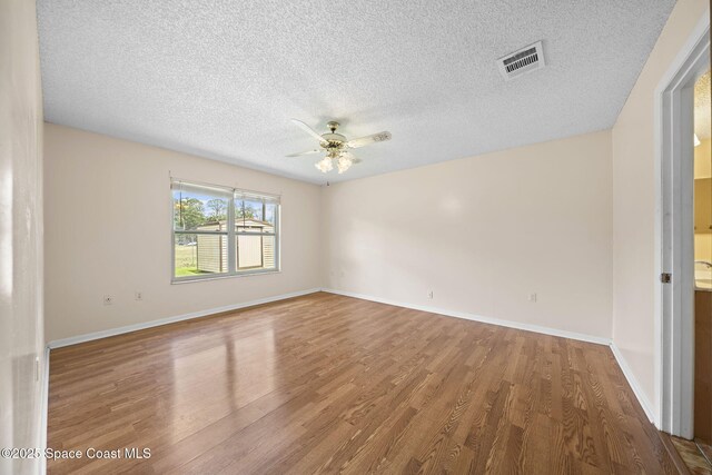 1401 Ruffin Cir SE, Palm Bay, FL 32909 - unfurnished room with wood finished floors, a textured ceiling, ceiling fan, and baseboards