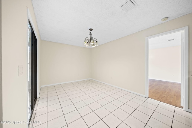 1401 Ruffin Cir SE, Palm Bay, FL 32909 - spare room featuring a textured ceiling, a smoke detector, a chandelier, light tile patterned floors, and baseboards