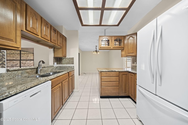 1401 Ruffin Cir SE, Palm Bay, FL 32909 - kitchen with white appliances, a sink, tasteful backsplash, light tile patterned floors, and brown cabinetry