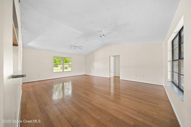 1401 Ruffin Cir SE, Palm Bay, FL 32909 - unfurnished living room featuring a ceiling fan, lofted ceiling, wood finished floors, baseboards, and a textured ceiling