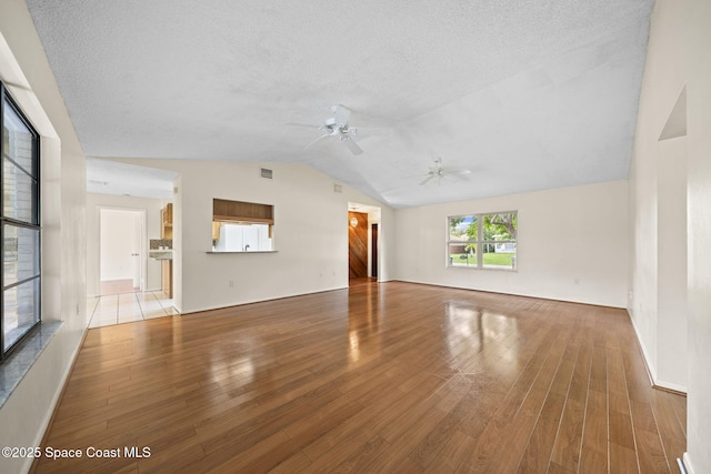 1401 Ruffin Cir SE, Palm Bay, FL 32909 - unfurnished living room featuring lofted ceiling, wood finished floors, ceiling fan, and a textured ceiling