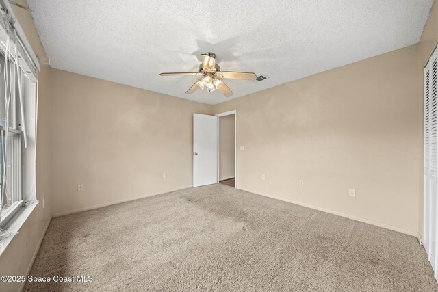 1401 Ruffin Cir SE, Palm Bay, FL 32909 - carpeted empty room with ceiling fan, a textured ceiling, and baseboards