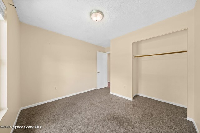 1401 Ruffin Cir SE, Palm Bay, FL 32909 - unfurnished bedroom with carpet flooring, a closet, baseboards, and a textured ceiling