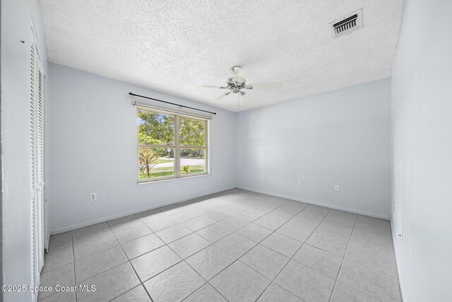1401 Ruffin Cir SE, Palm Bay, FL 32909 - tiled spare room with ceiling fan, a textured ceiling, and baseboards